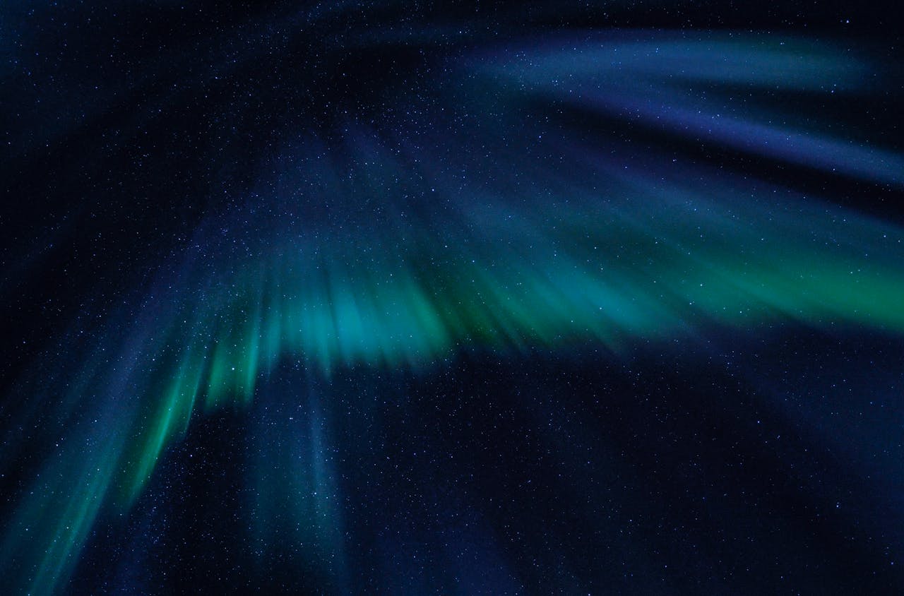 Breathtaking view of the aurora borealis illuminating the starry night sky with vibrant green and blue hues.